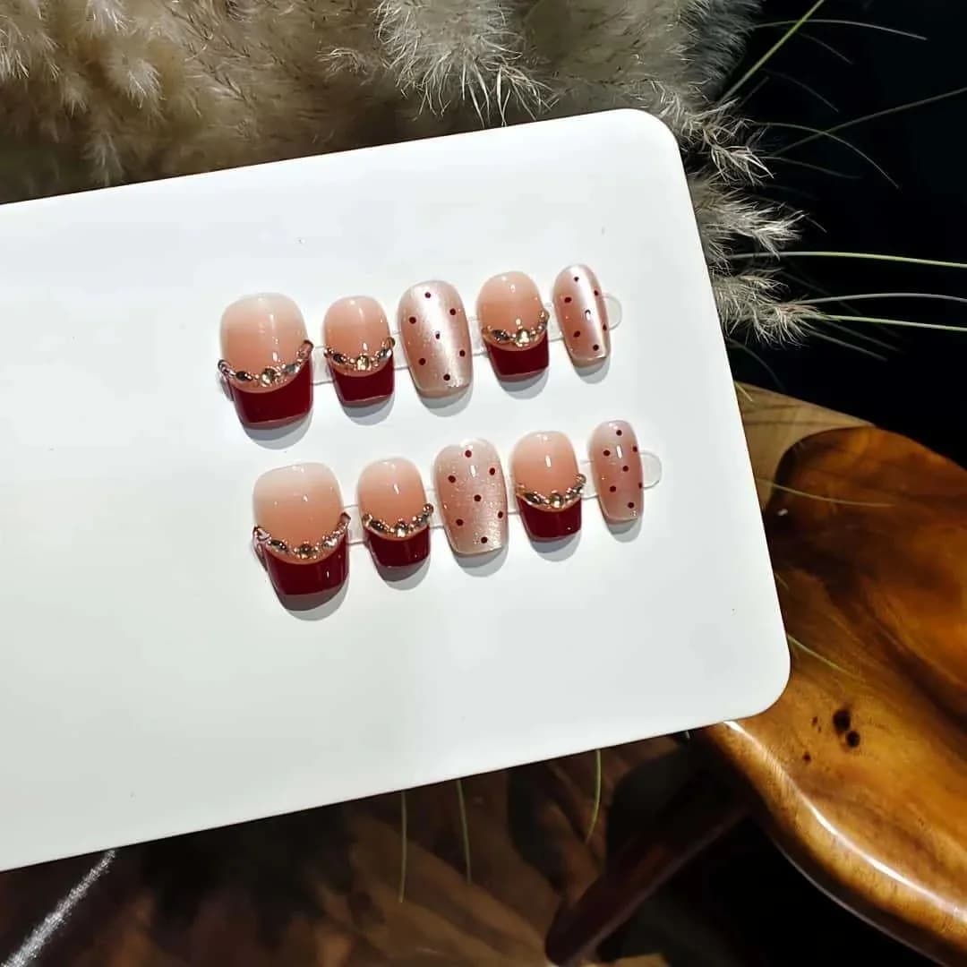 Unghii false Cat Eye roșu-maroniu cu pietre strălucitoare